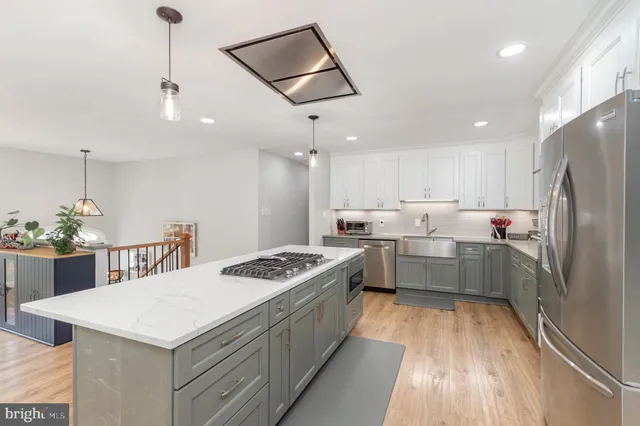 a kitchen with a stove a refrigerator a sink and dishwasher with wooden floor