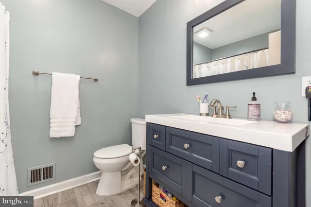 a bathroom with a sink vanity mirror and toilet