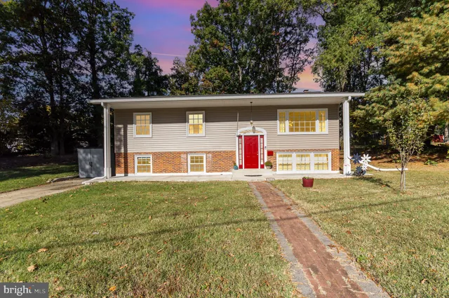 a front view of house with yard and trees in the background
