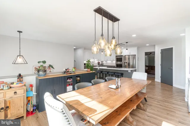 a room with stainless steel appliances kitchen island granite countertop furniture and a chandelier