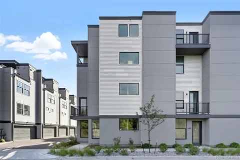 a front view of a multi story residential apartment building with yard