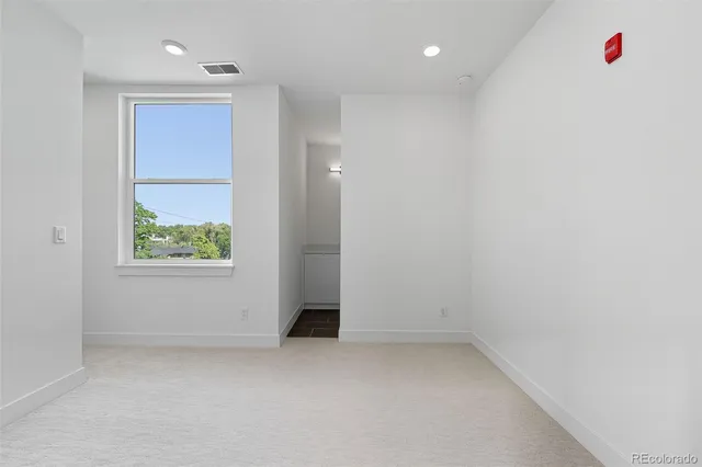 an empty room with an entryway and window