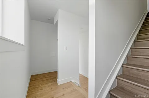 a view of a hallway with wooden floor and entryway