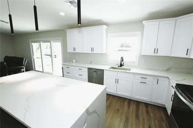 a kitchen with a sink a stove and cabinets