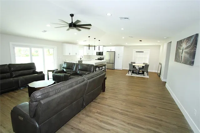 a living room with furniture and a wooden floor