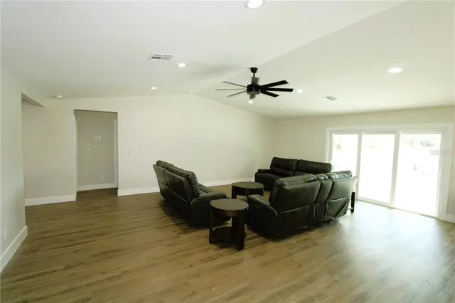 a living room with furniture and a wooden floor