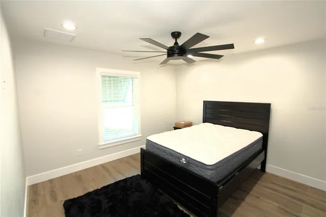 a white bedroom with a bed and a chandelier