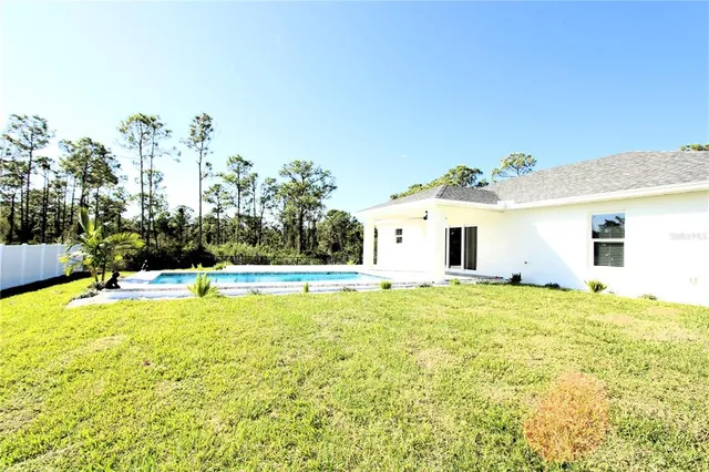 a view of a house with a swimming pool and a yard
