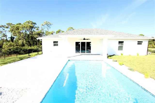 a big white house with a big yard and large trees