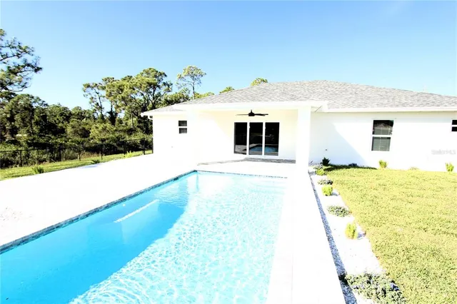 a view of a house with pool and a yard