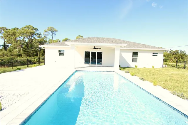 a view of a house with backyard sitting area and garden