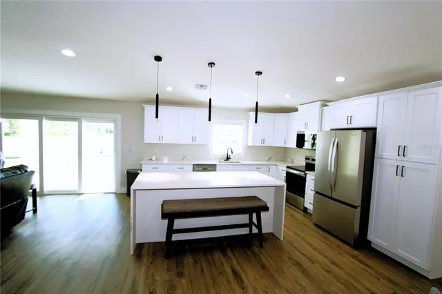a kitchen with a refrigerator a sink and cabinets