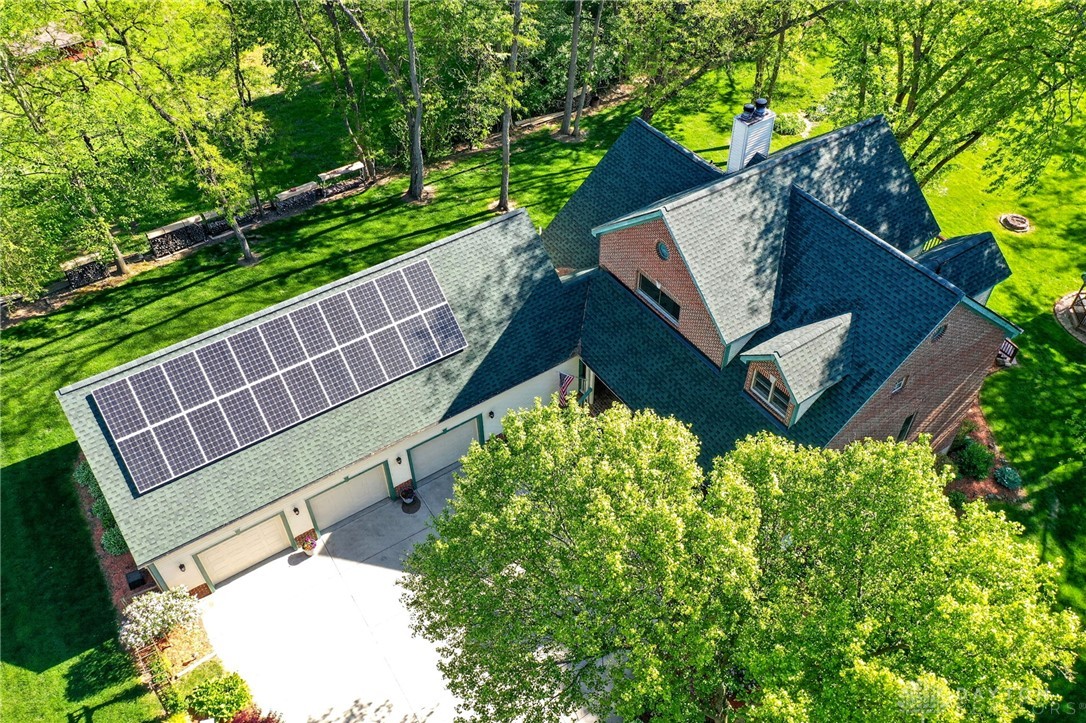 330 South Alpha Bellbrook Road Bellbrook, OH 45305 - Photo 66 of 87 This aerial view showcases a house with solar panels, a lush green lawn, and mature trees.