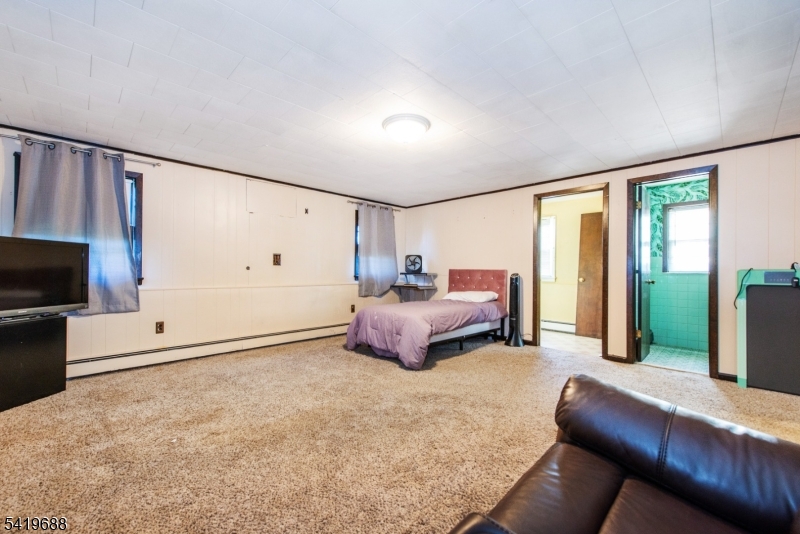 127 Horseneck Road Fairfield, NJ 07004 - Photo 25 of 34 a bedroom with furniture and a flat screen tv