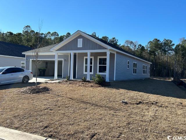 View of front of house with a garage, covered porch, board and batten siding, and concrete driveway