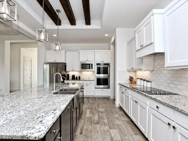 a kitchen with kitchen island granite countertop lots of counter top space stainless steel appliances and cabinets