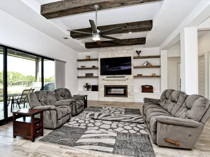 a living room with furniture a fireplace and a flat screen tv