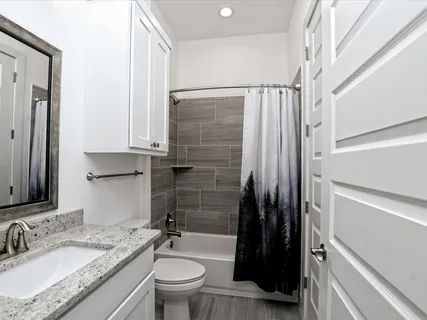 a bathroom with a granite countertop sink toilet and shower