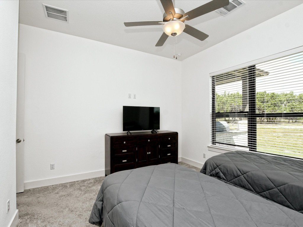 113 Tesoro Perdido Cove Liberty Hill, TX 78642 - Photo 25 of 31 a bedroom with a bed and a flat screen tv