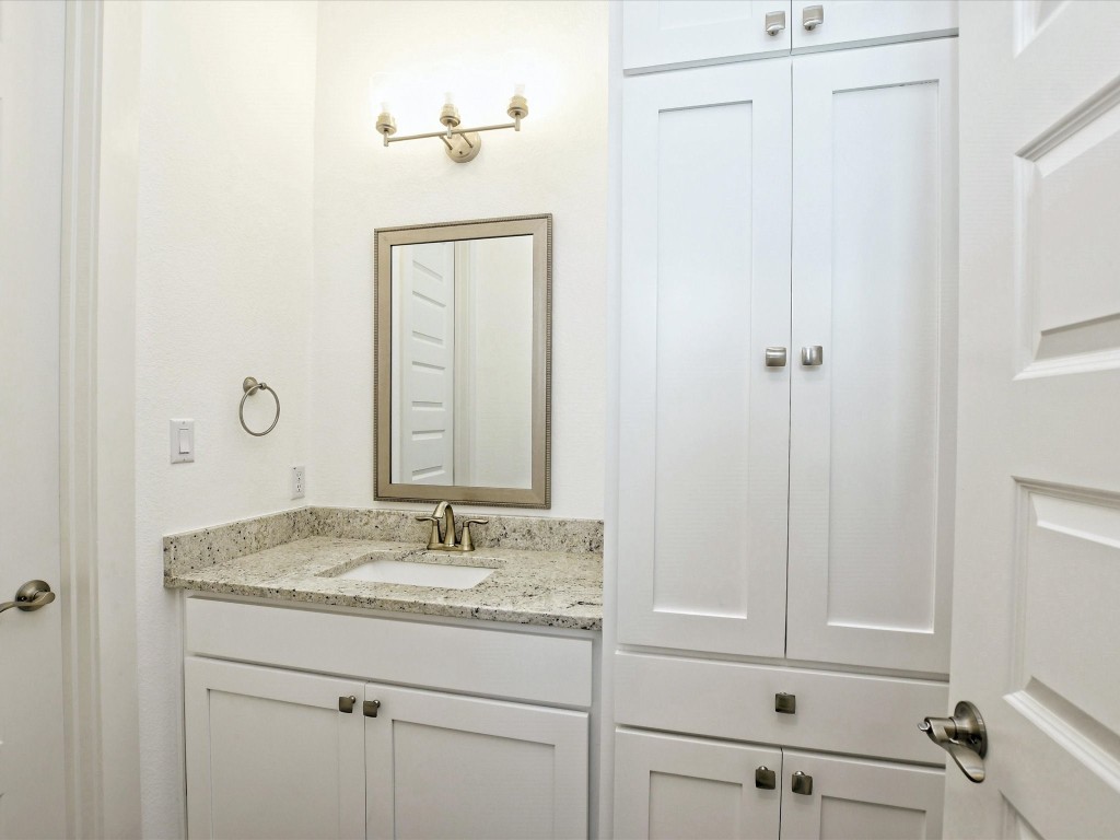 113 Tesoro Perdido Cove Liberty Hill, TX 78642 - Photo 27 of 31 a bathroom with a granite countertop sink and a mirror
