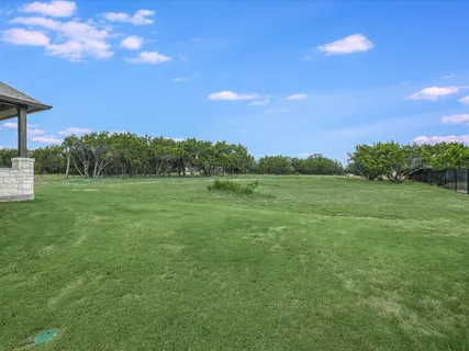 a view of a big yard with a house in the background