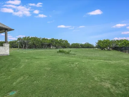 a view of a big yard with a house in the background