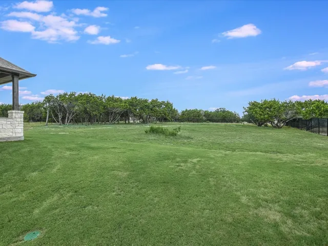 a view of a big yard with a house in the background