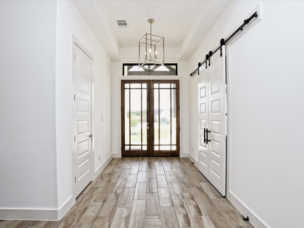 113 Tesoro Perdido Cove Liberty Hill, TX 78642 - Photo 7 of 31 a view of a hallway with wooden floor and staircase