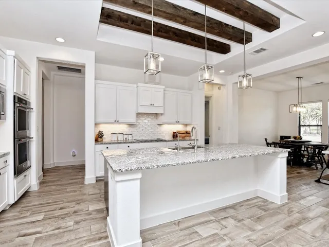 a large kitchen with stainless steel appliances kitchen island granite countertop a sink and cabinets