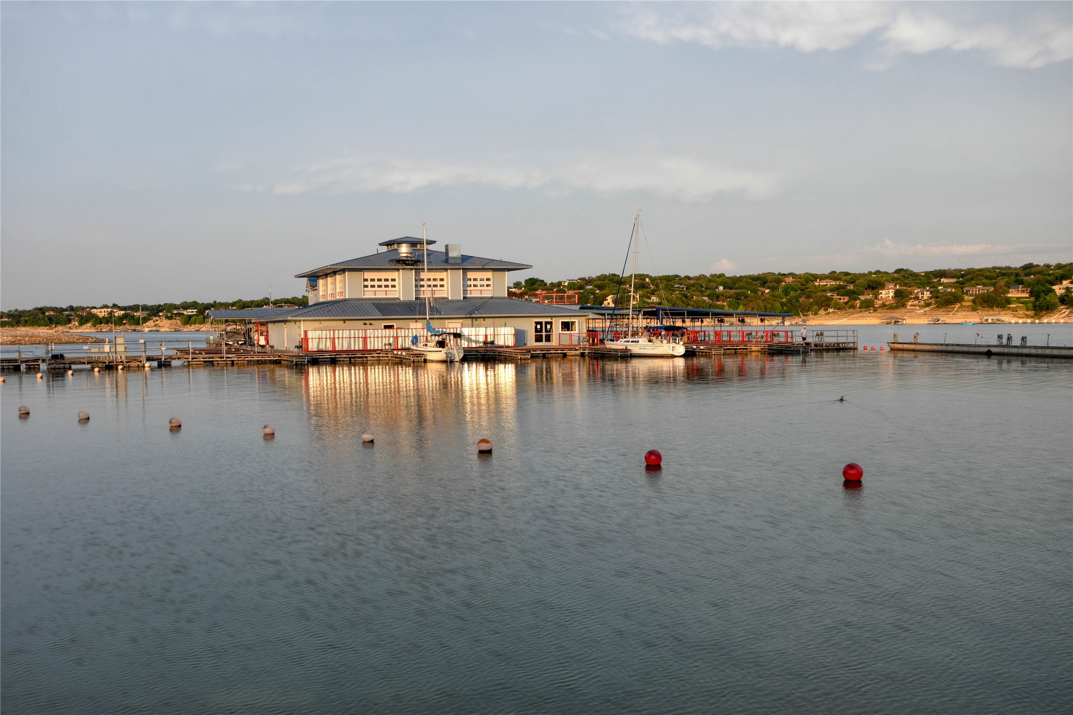 565 Demarett Drive Point Venture, TX 78645 - Photo 24 of 46 a view of a lake with boats and trees in the background
