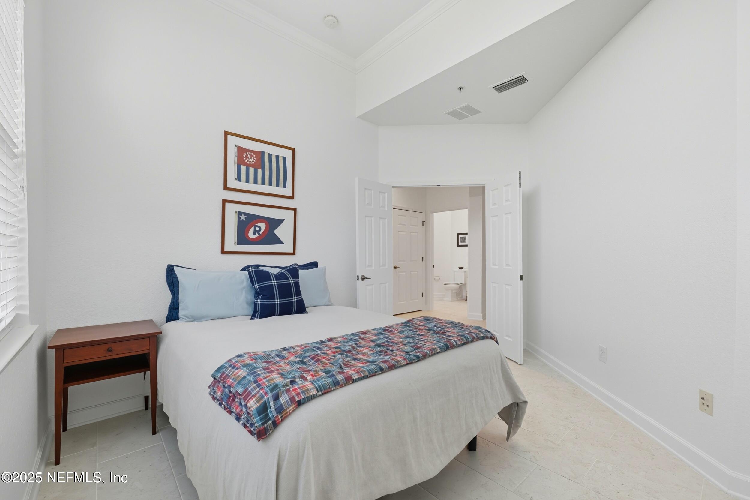 210 Paseo Terraza, Unit 301 St. Augustine, FL 32095 - Photo 27 of 54 a bedroom with a bed and a lamp on dresser