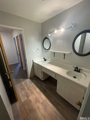 a bathroom with a double vanity sink a mirror and bathtub