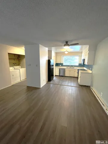 a kitchen with a wooden floor and a large window