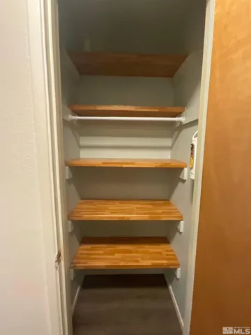 a view of walk in closet with empty racks