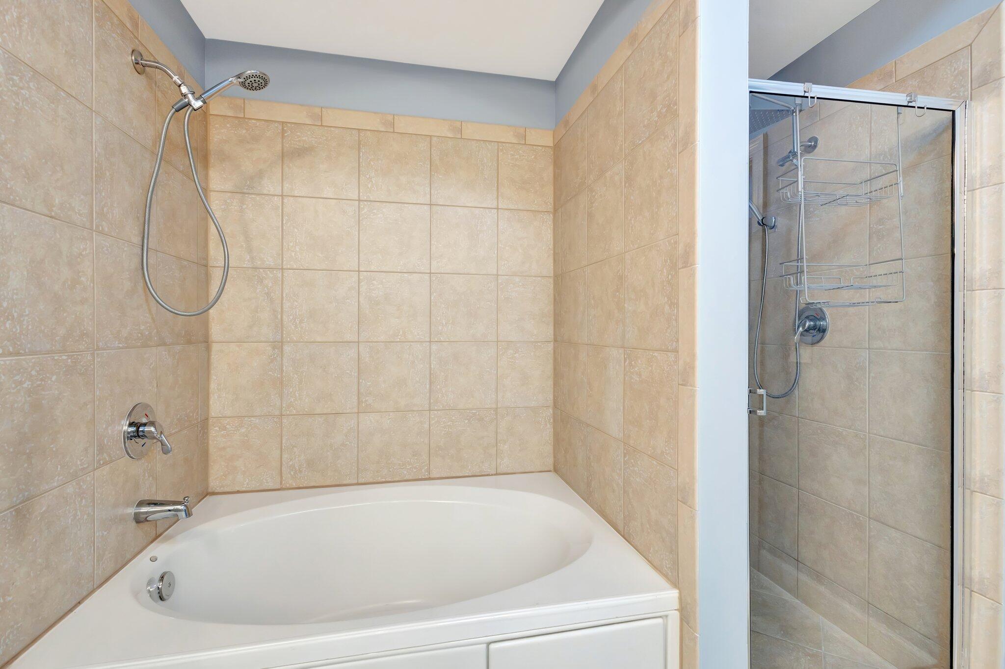 1690 Renaissance Commons Boulevard, Unit 1401 Boynton Beach, FL 33426 - Photo 12 of 41 a white bath tub sitting next to a shower