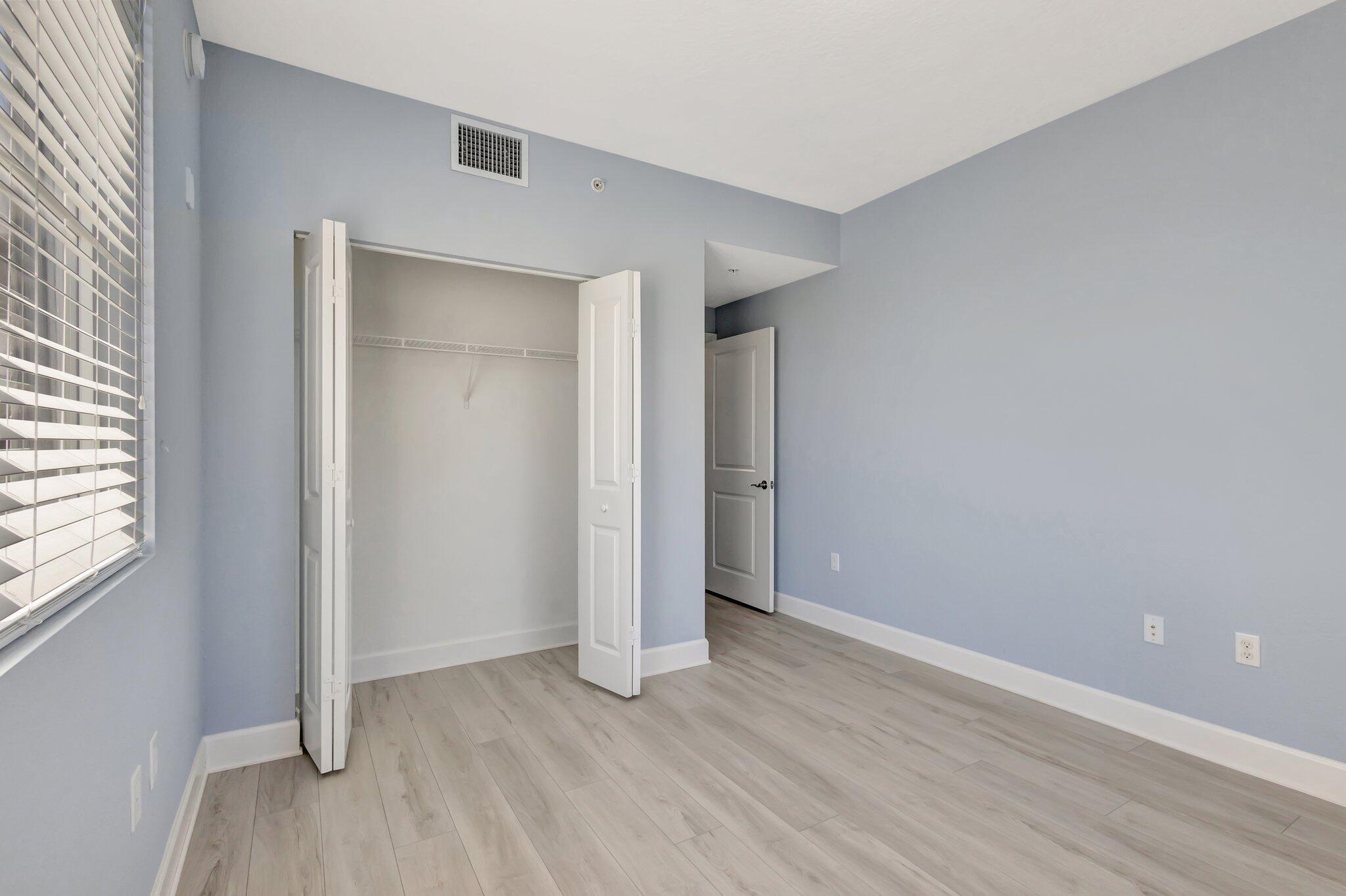 1690 Renaissance Commons Boulevard, Unit 1401 Boynton Beach, FL 33426 - Photo 21 of 41 an empty room with wooden floor and windows