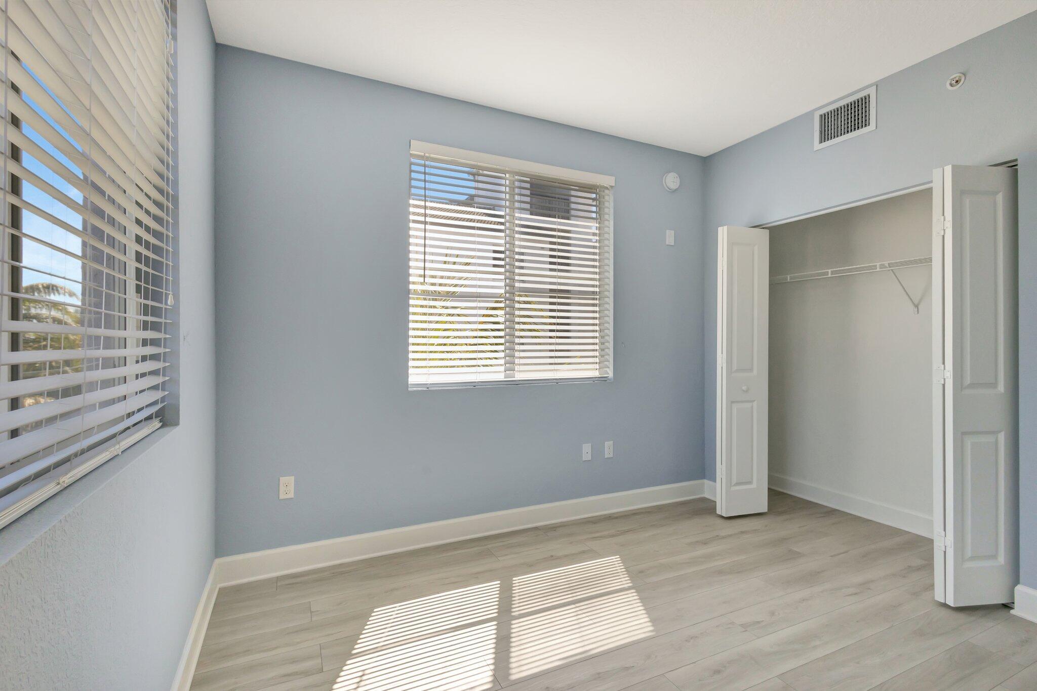 1690 Renaissance Commons Boulevard, Unit 1401 Boynton Beach, FL 33426 - Photo 22 of 41 a view of an empty room with wooden floor and a window