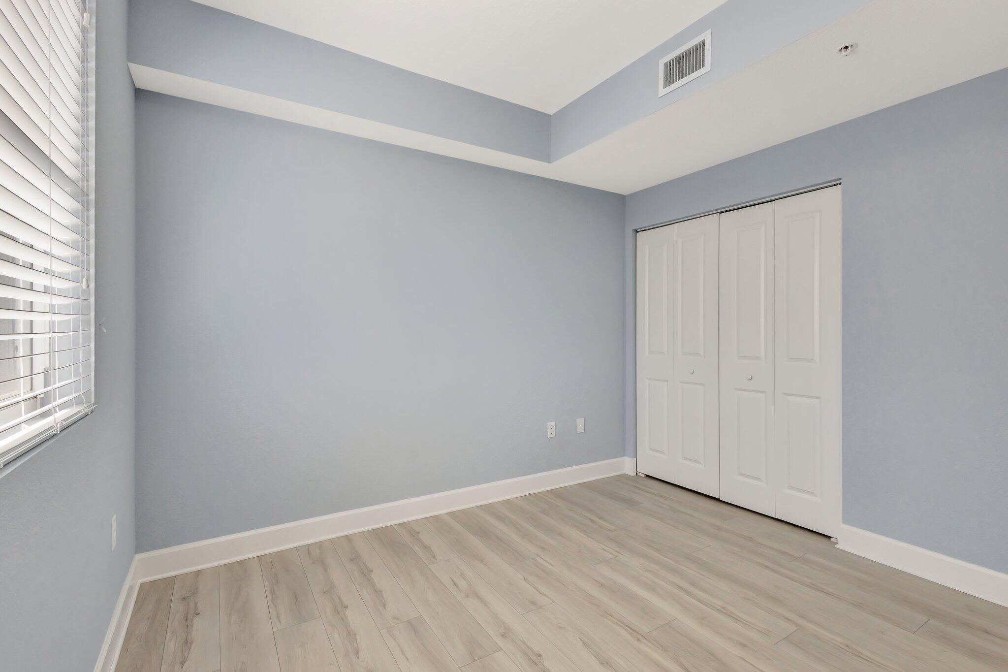 1690 Renaissance Commons Boulevard, Unit 1401 Boynton Beach, FL 33426 - Photo 29 of 41 an empty room with wooden floor and windows