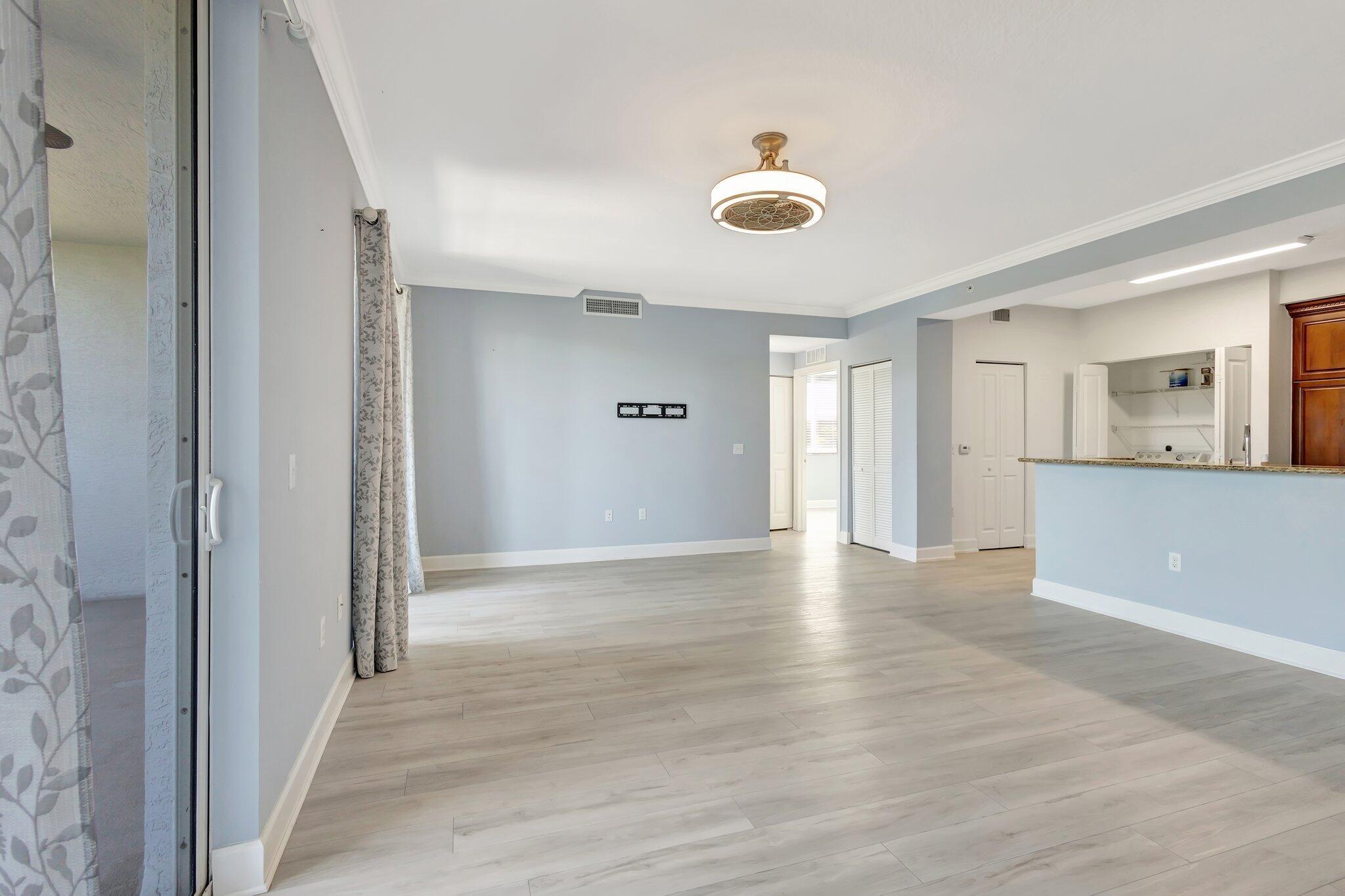 1690 Renaissance Commons Boulevard, Unit 1401 Boynton Beach, FL 33426 - Photo 33 of 41 a view of an empty room with wooden floor and a window
