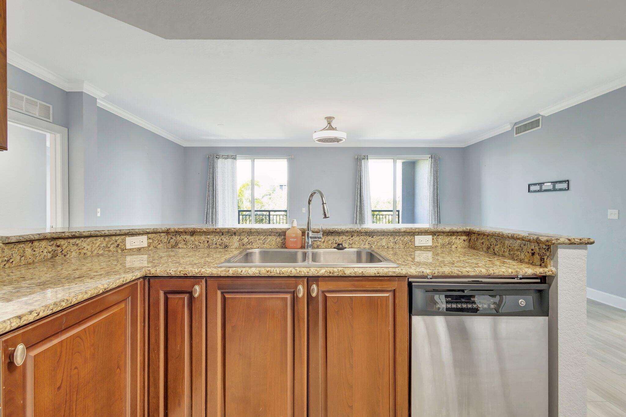 1690 Renaissance Commons Boulevard, Unit 1401 Boynton Beach, FL 33426 - Photo 4 of 41 a kitchen with granite countertop a sink and a granite counter tops