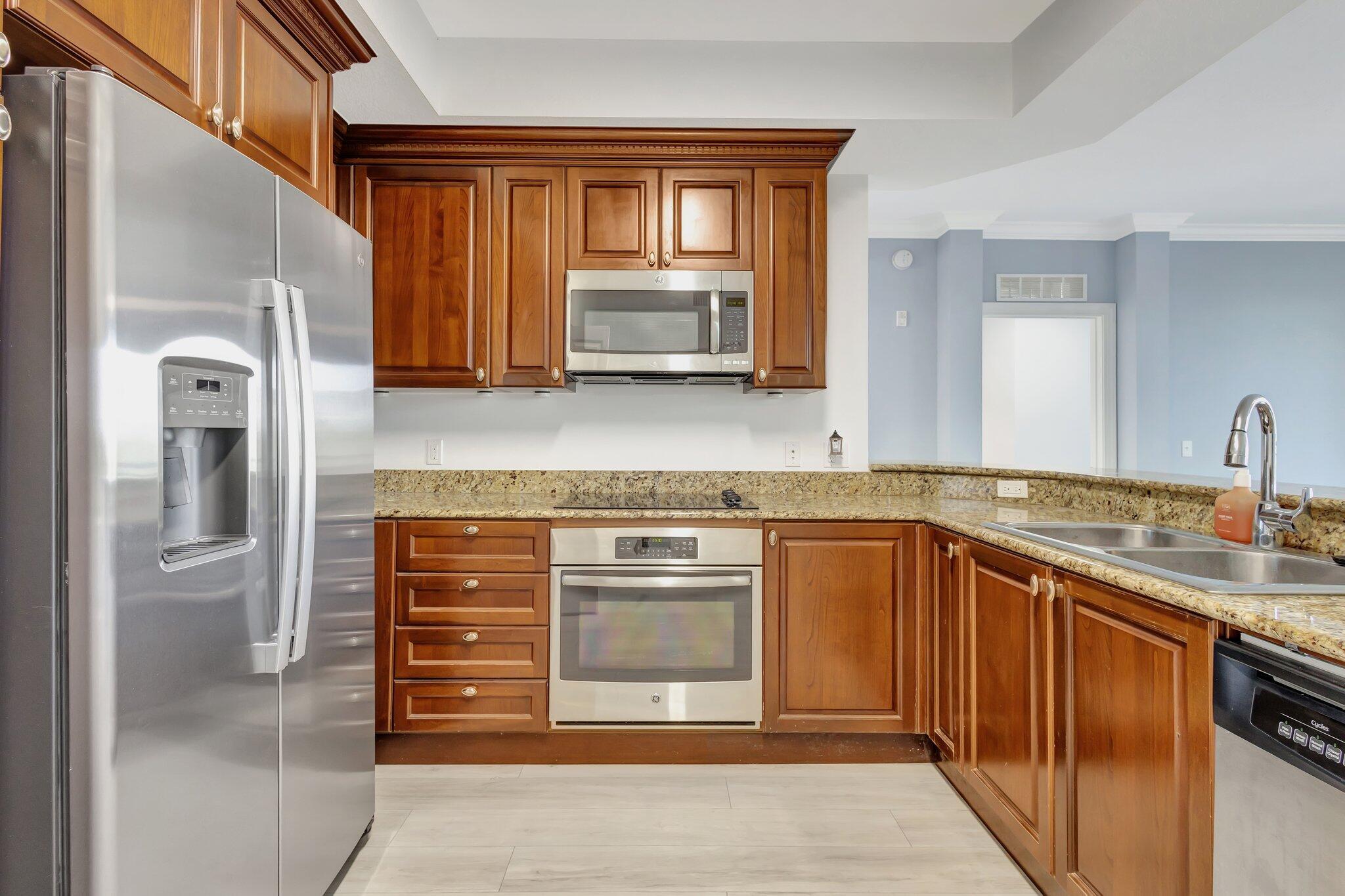1690 Renaissance Commons Boulevard, Unit 1401 Boynton Beach, FL 33426 - Photo 6 of 41 a kitchen with stainless steel appliances granite countertop a stove and a sink