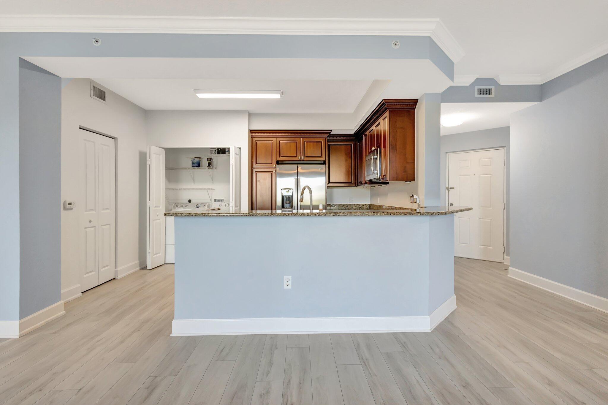 1690 Renaissance Commons Boulevard, Unit 1401 Boynton Beach, FL 33426 - Photo 7 of 41 a living room with stainless steel appliances kitchen island wooden floors and view living room