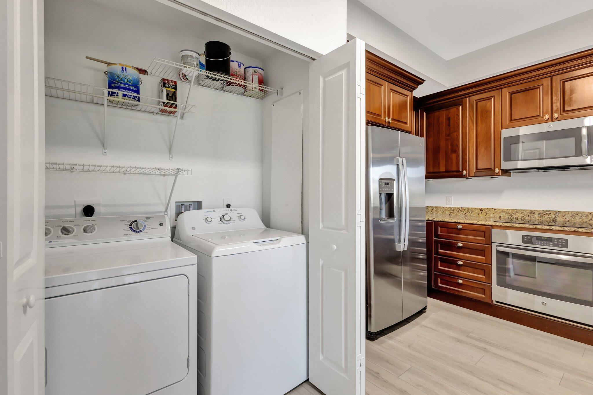 1690 Renaissance Commons Boulevard, Unit 1401 Boynton Beach, FL 33426 - Photo 9 of 41 a kitchen with a refrigerator and a stove top oven