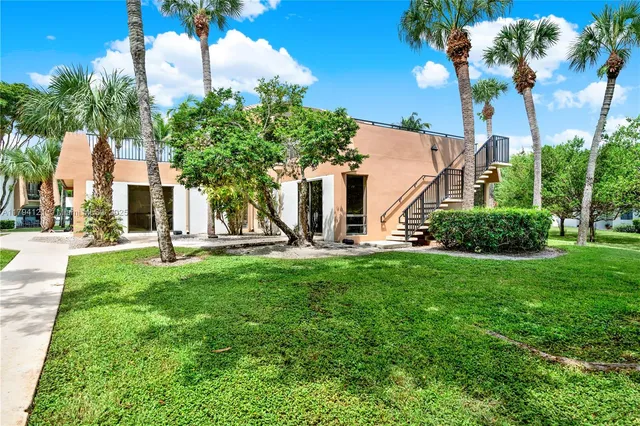 a view of a white house with a yard and plants