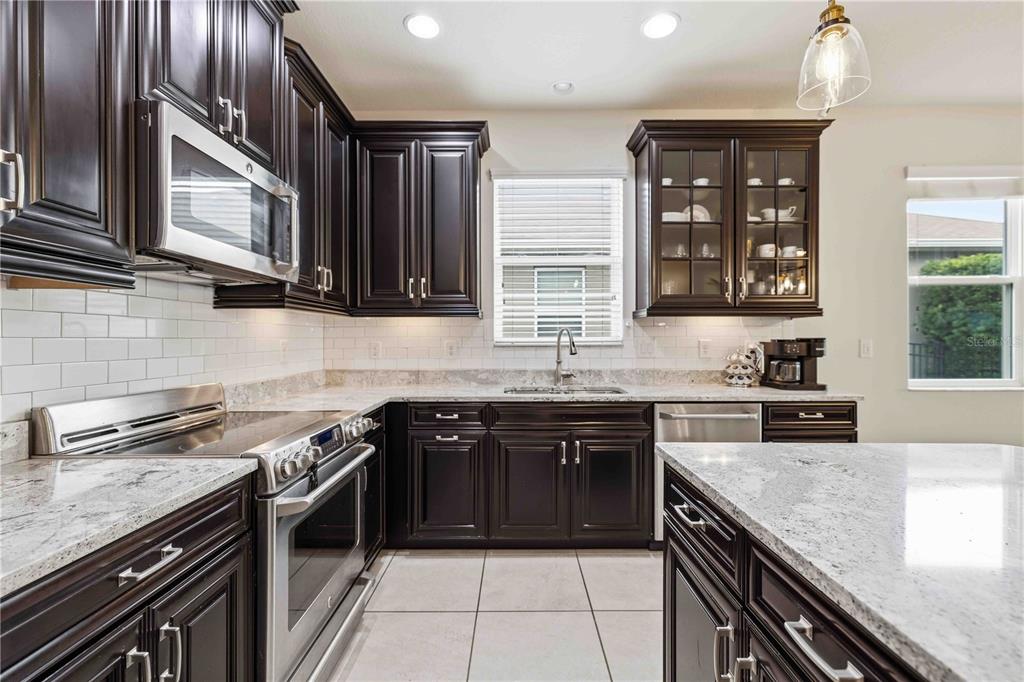 10920 79th Street East Parrish, FL 34219 - Photo 10 of 73 a kitchen with stainless steel appliances granite countertop a stove microwave and sink