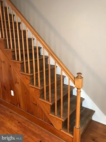 a view of staircase with railing and white walls
