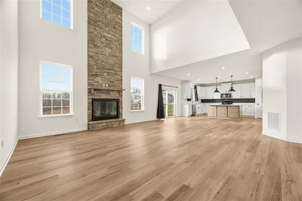 a view of empty room with wooden floor and fireplace