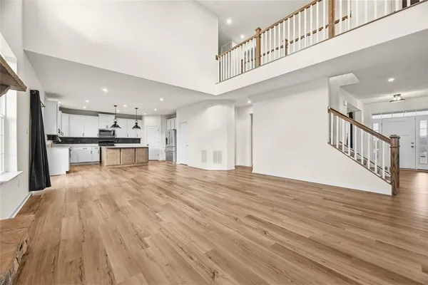 a view of kitchen with kitchen island wooden floor center island and a chandelier