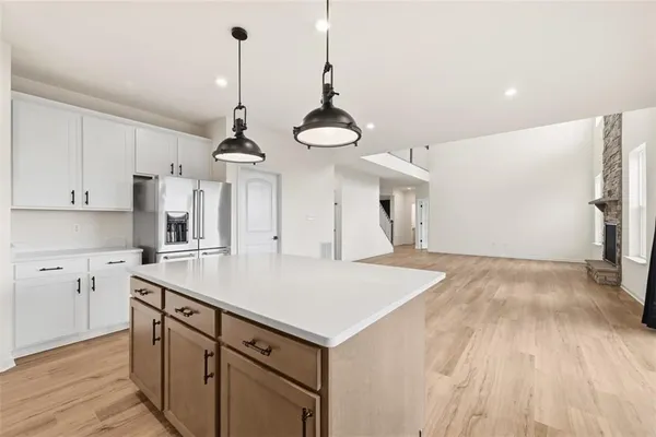 a kitchen with a sink chandelier and wooden floor