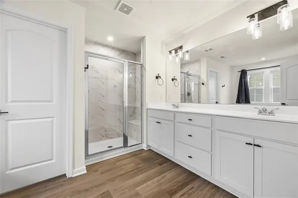 a bathroom with a double vanity sink mirror and shower